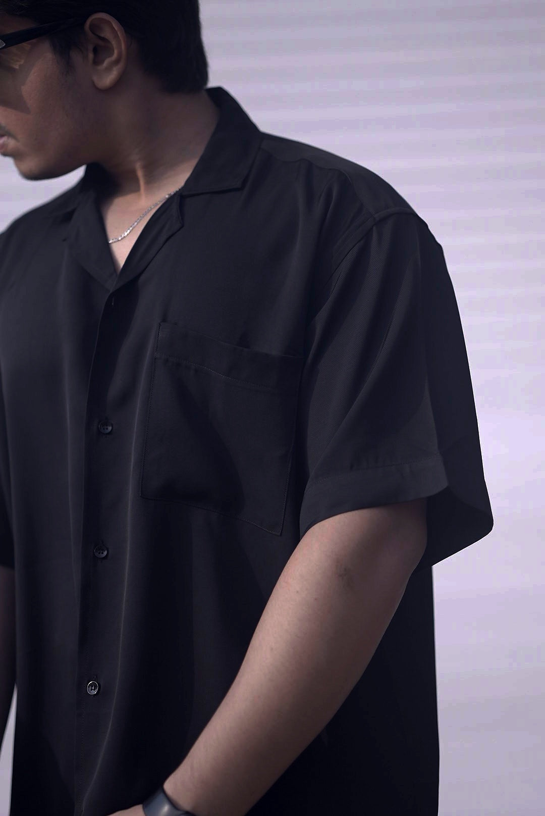 Side angle of noir cuban shirt showing drop shoulder construction