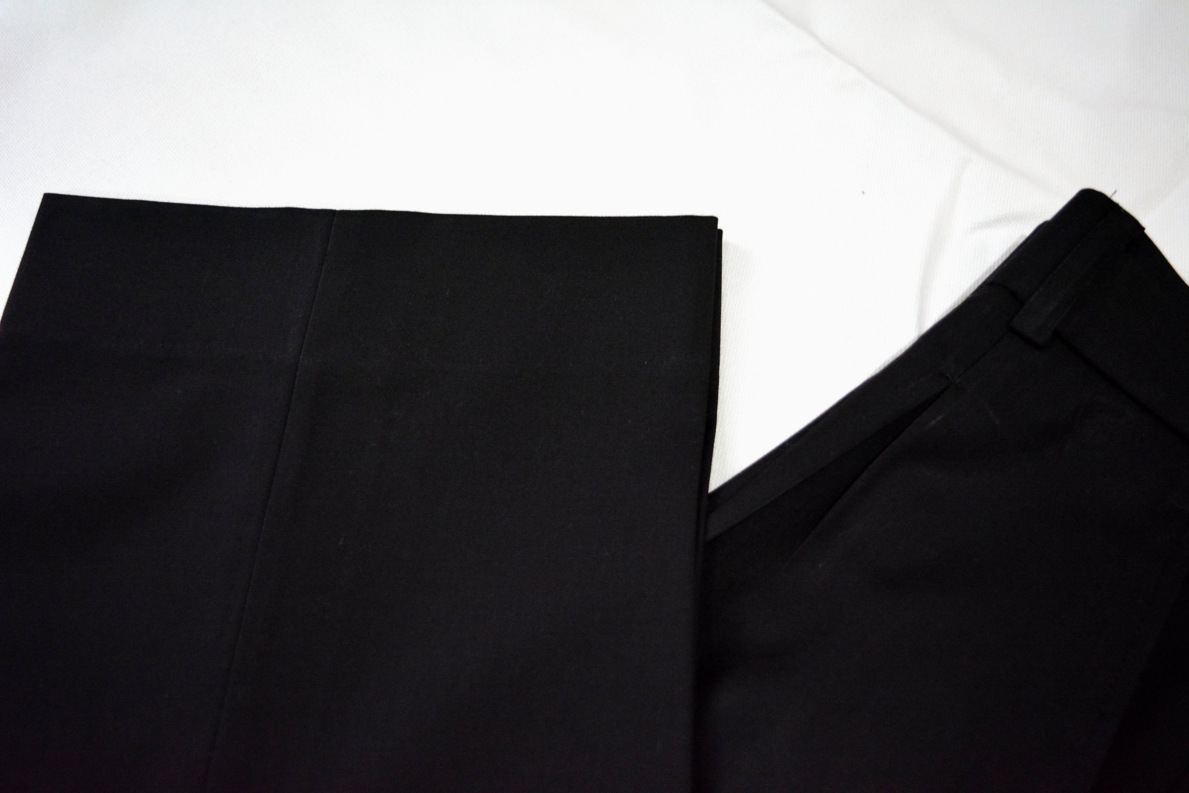 Black loose pleated pants fabric texture showing soft, breathable weave