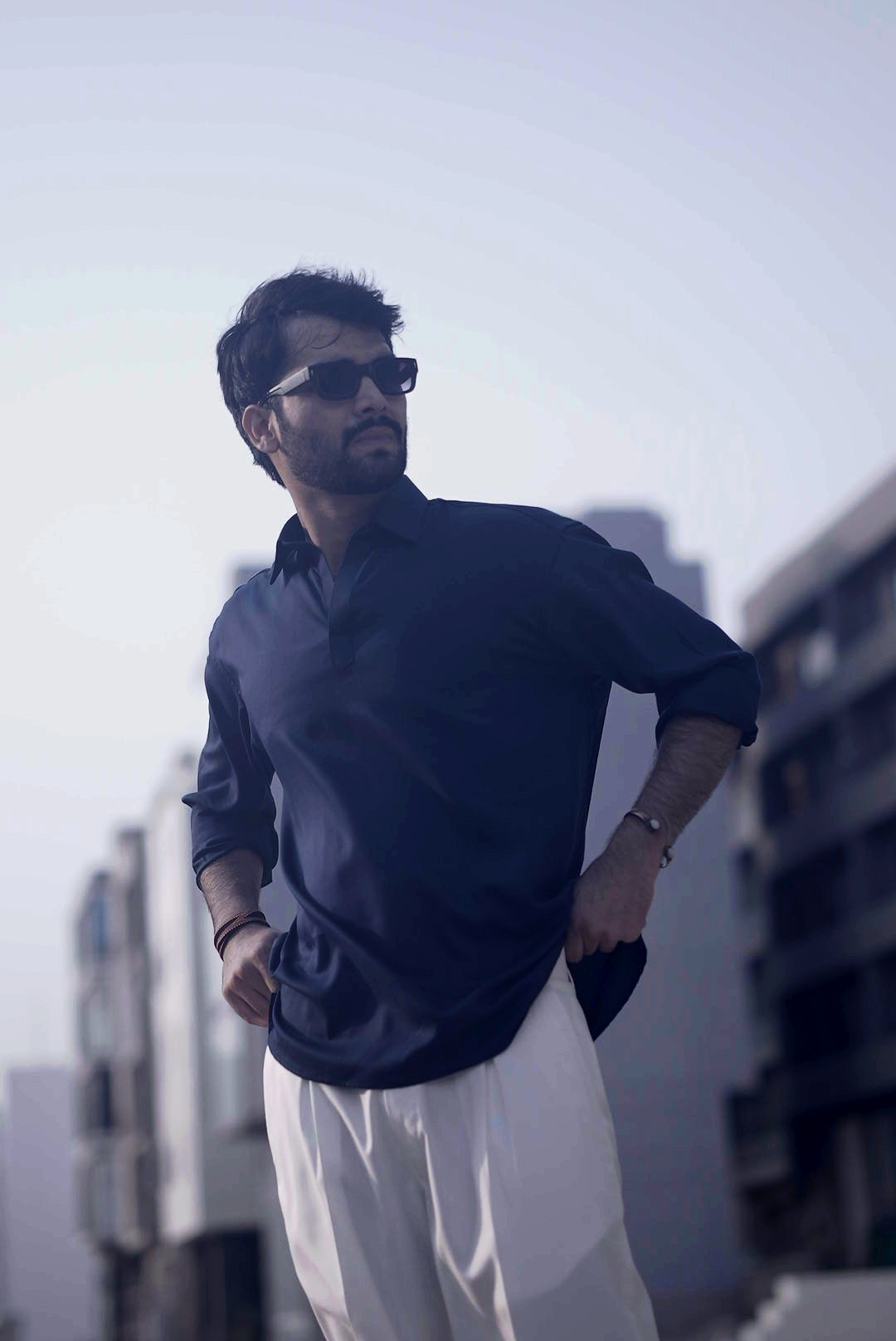 navy blue open collar shirt men styled with white pleated pant