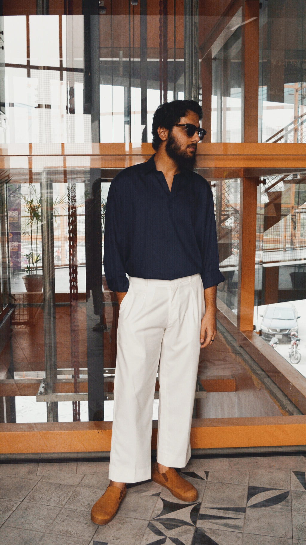 white pleated loose pant styled with a navy blue open collar sleek shirt